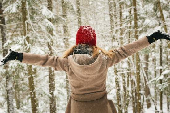 woman coping with winter blues by playing in snow